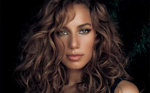 HD desktop wallpaper featuring a close-up portrait of Leona Lewis with wavy hair and green eyes, highlighting music and artistic expression.