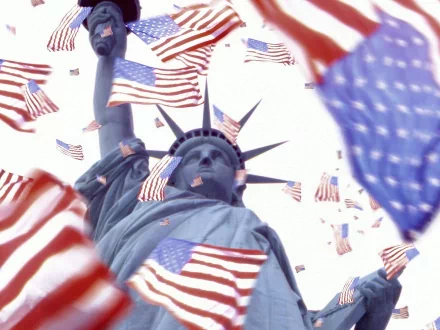 A vibrant HD desktop wallpaper featuring the Statue of Liberty surrounded by flying American flags, symbolizing patriotism and freedom.