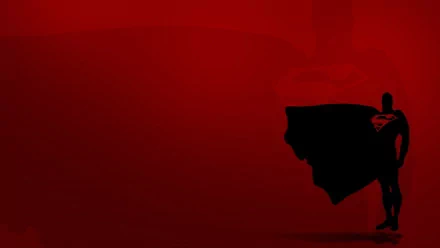 A striking HD desktop wallpaper featuring Superman against a bold red background, illustrating the iconic superhero in a dynamic pose with his cape flowing dramatically.