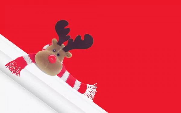 A cheerful reindeer wearing a striped scarf pops against a vibrant red background, embodying the festive spirit of the holiday and Christmas season. An engaging HD desktop wallpaper.