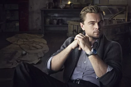 A stylish HD desktop wallpaper featuring Leonardo DiCaprio, exuding a thoughtful demeanor as he poses in an artistic setting, highlighting his charismatic presence.