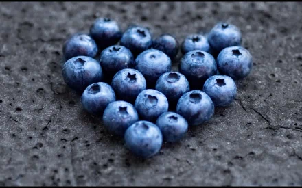 HD PC desktop wallpaper: fresh blueberries arranged in a heart on a dark textured background — close-up food image.