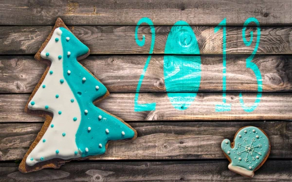 HD desktop wallpaper featuring a decorated holiday cookie shaped like a Christmas tree and mitten, with 2013 written in bright blue, celebrating New Year 2013.