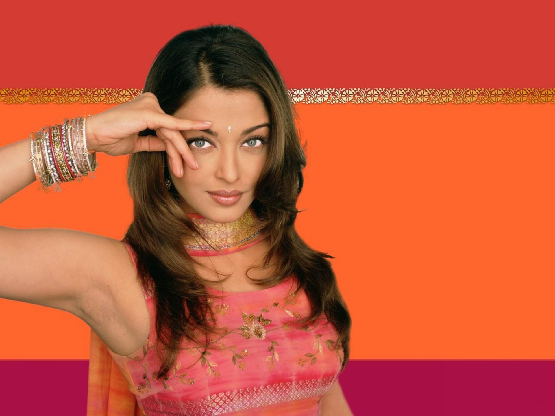 HD desktop wallpaper featuring celebrity Aishwarya Rai in a pink traditional outfit against a vibrant orange and red background.
