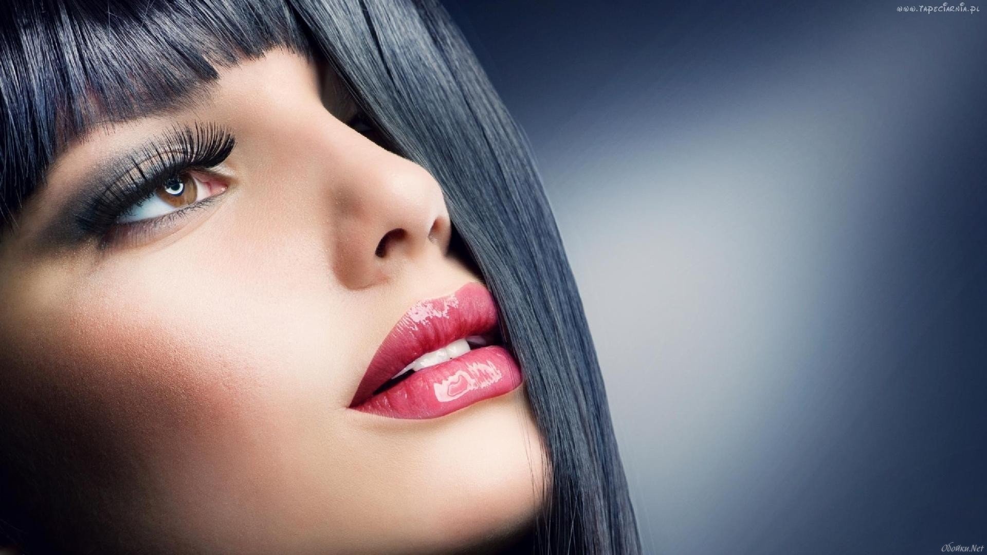 HD PC desktop wallpaper featuring a close-up of a woman's face with smooth skin, dark hair, and glossy red lips against a soft gradient background.