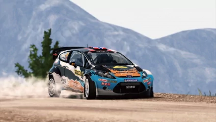 HD wallpaper of a WRC 3 rally car speeding on a gravel road with mountains in the background.