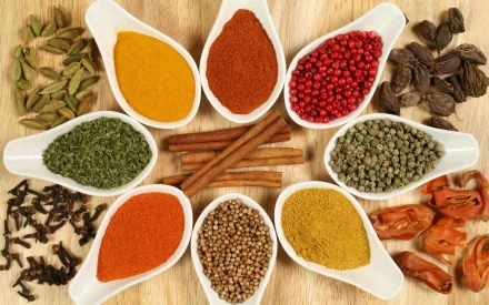 Vibrant assortment of herbs and spices arranged in white spoons on a wooden surface, displayed as an HD PC desktop wallpaper and background.