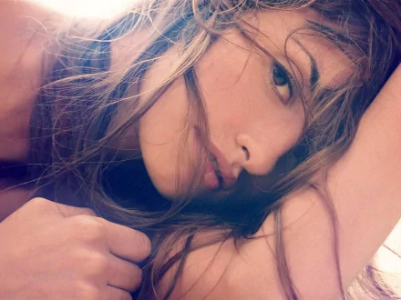 Close-up HD desktop wallpaper of celebrity Penelope Cruz with tousled hair and a soft, contemplative expression.