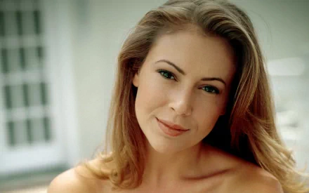 HD PC desktop wallpaper featuring a close-up portrait of celebrity Alyssa Milano with a soft smile and natural makeup against a blurred background.