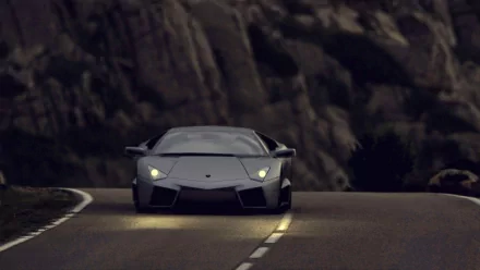 HD wallpaper of a Lamborghini Reventón driving on a mountain road at dusk.