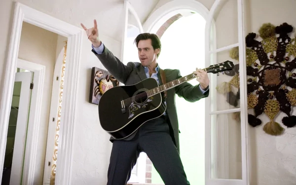 HD desktop wallpaper featuring Jim Carrey from the movie Yes Man, playing a black guitar with a lively expression in a bright, open room.