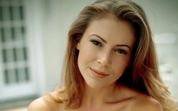 HD PC desktop wallpaper featuring a close-up portrait of celebrity Alyssa Milano with a soft smile and natural makeup against a blurred background.