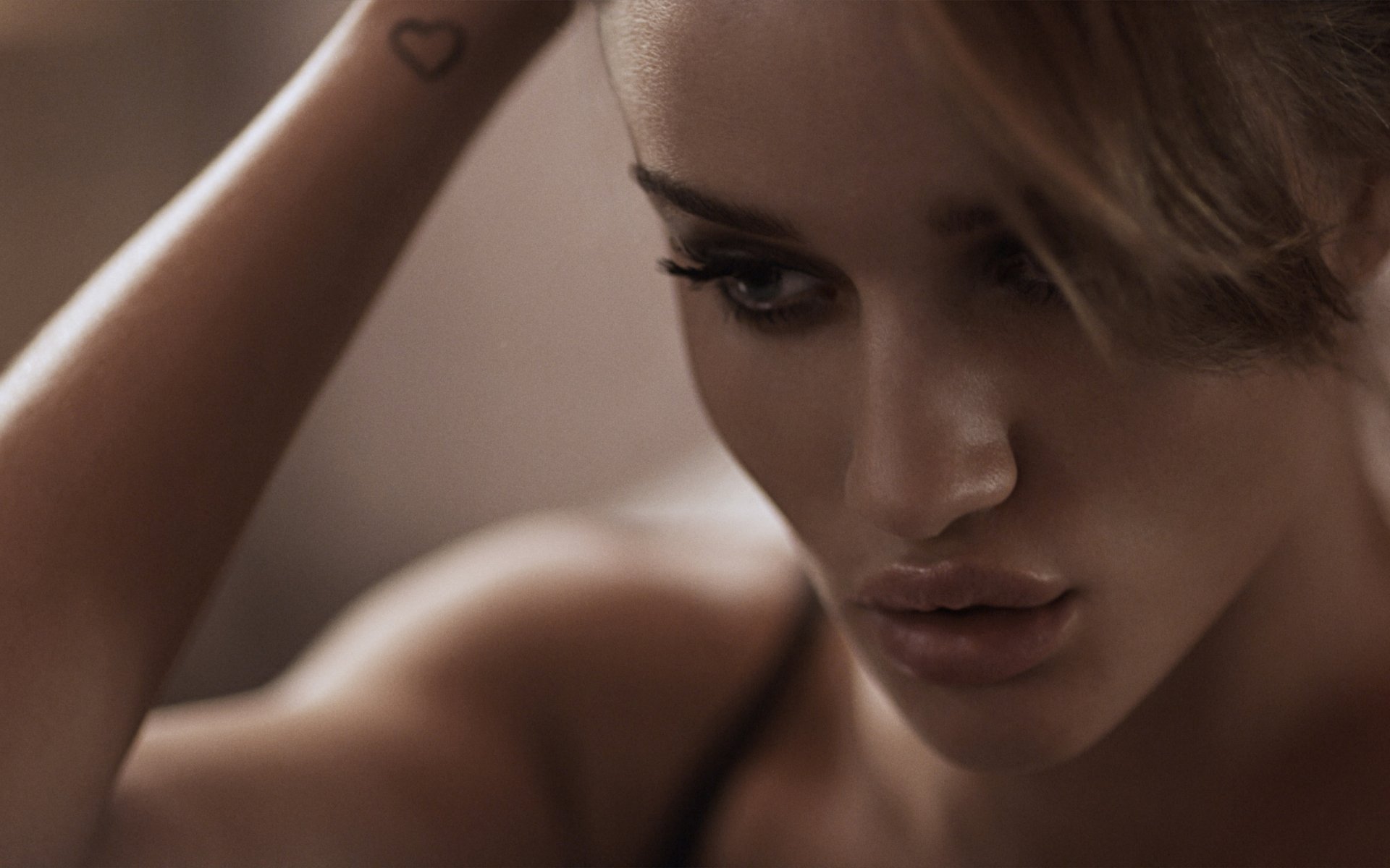 Close-up of Rosie Huntington-Whiteley with sleek hair and striking makeup, showcasing her captivating features in a high-definition desktop wallpaper.