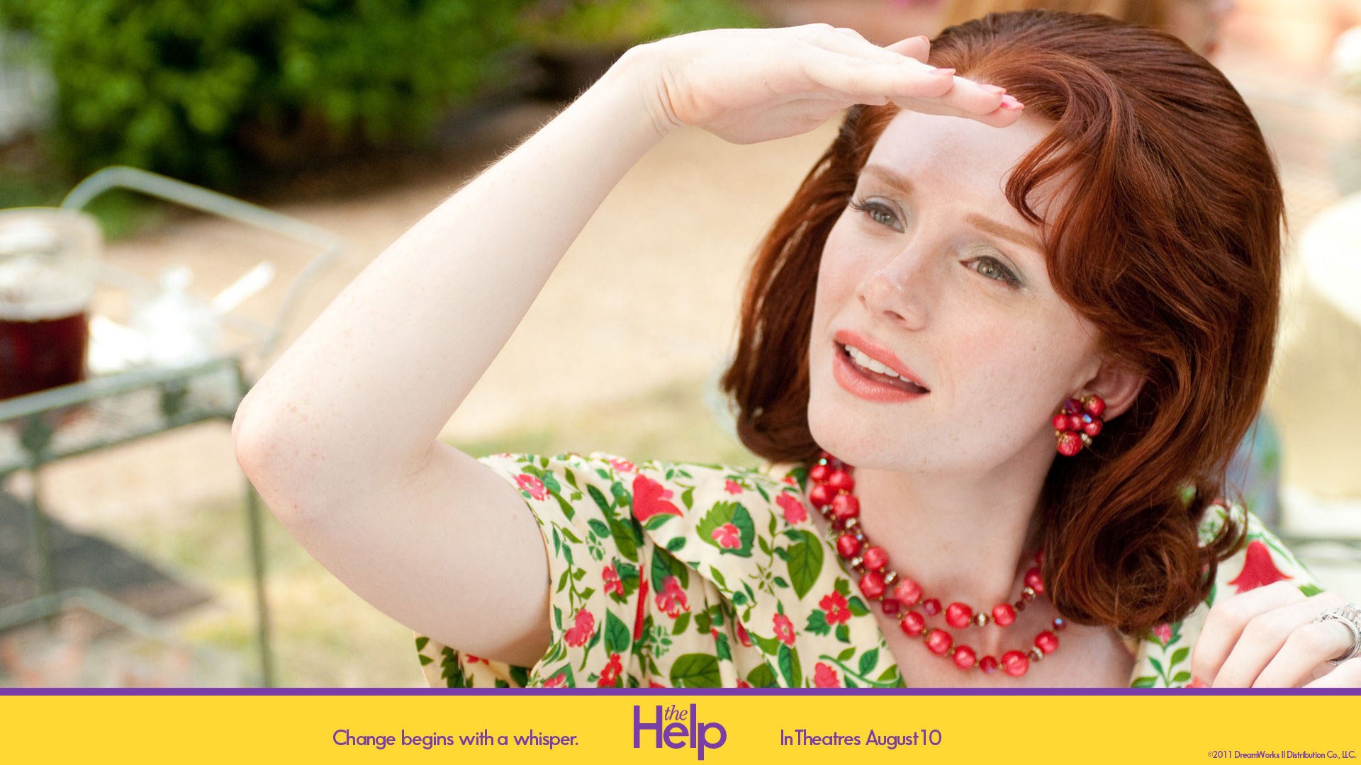 HD wallpaper featuring Bryce Dallas Howard from The Help, gazing into the distance with a hand shading her eyes.