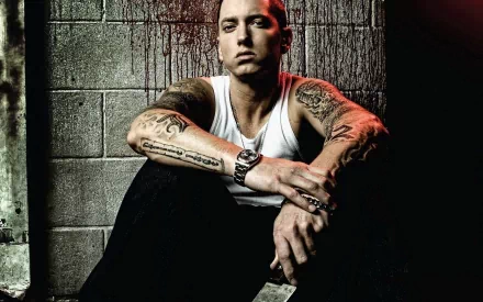 HD desktop wallpaper featuring Eminem, capturing his intense expression and tattoos against a gritty backdrop, embodying the essence of his music and persona.