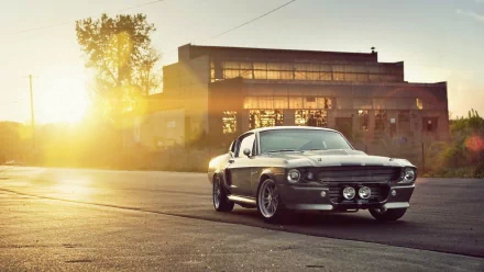 HD desktop wallpaper featuring a Ford Mustang posed at sunset with an industrial backdrop.