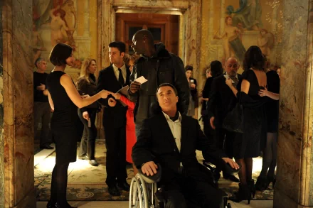 HD desktop wallpaper from Intouchables featuring characters at an elegant party in a detailed, mural-adorned hallway.