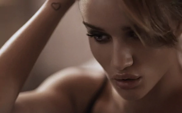 Close-up of Rosie Huntington-Whiteley with sleek hair and striking makeup, showcasing her captivating features in a high-definition desktop wallpaper.