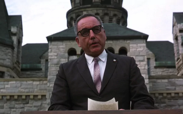 HD desktop wallpaper featuring a character from The Shawshank Redemption, portrayed by Bob Gunton, set against a stone building backdrop.