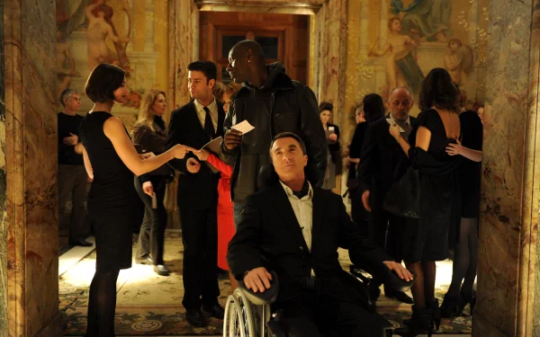 HD desktop wallpaper from Intouchables featuring characters at an elegant party in a detailed, mural-adorned hallway.