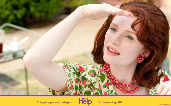 HD wallpaper featuring Bryce Dallas Howard from The Help, gazing into the distance with a hand shading her eyes.