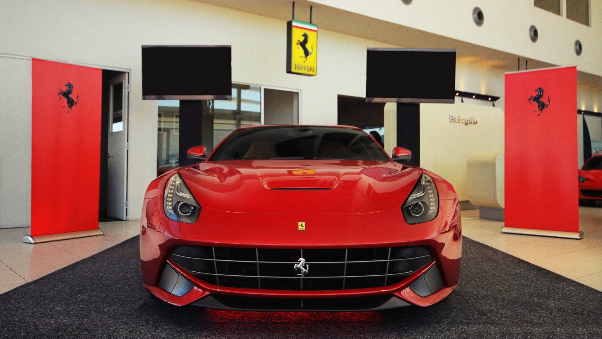 Red Ferrari F12berlinetta on display, showcased as a high-definition desktop wallpaper and background.