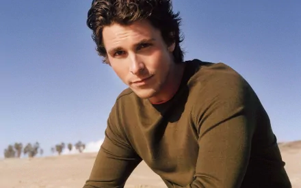 HD PC desktop wallpaper featuring a portrait of celebrity Christian Bale against a clear sky and desert backdrop.