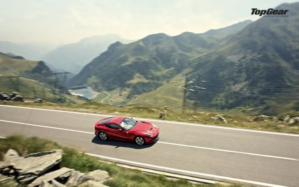 HD desktop wallpaper featuring a red Ferrari F12berlinetta driving on a mountainous road with scenic views.