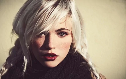 A striking HD desktop wallpaper featuring a woman with blonde hair and captivating blue eyes, exuding a unique and confident presence. Ideal background for various aesthetics.