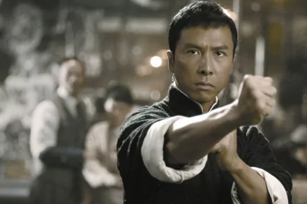 A dramatic scene from the movie Ip Man, featuring the main character in a fighting stance, set against a blurred background. HD wallpaper captures the intensity of martial arts.
