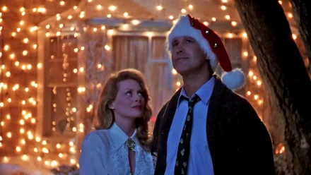 HD PC wallpaper: scene from National Lampoon's Christmas Vacation — couple standing before a house draped in twinkling Christmas lights, man in a Santa hat gazing up.
