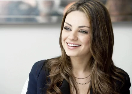 Mila Kunis smiles brightly in this 4K Ultra HD desktop wallpaper, showcasing her elegant style and charisma. A captivating background image for fans.