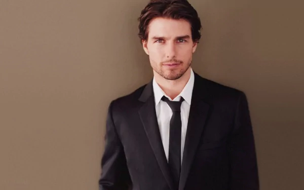 A high-definition desktop wallpaper featuring Tom Cruise, dressed in a smart suit against a neutral background, showcasing his classic charisma and style.