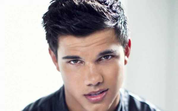 HD desktop wallpaper featuring Taylor Lautner, showcasing a close-up of his confident expression and stylish hairstyle against a softly blurred background.