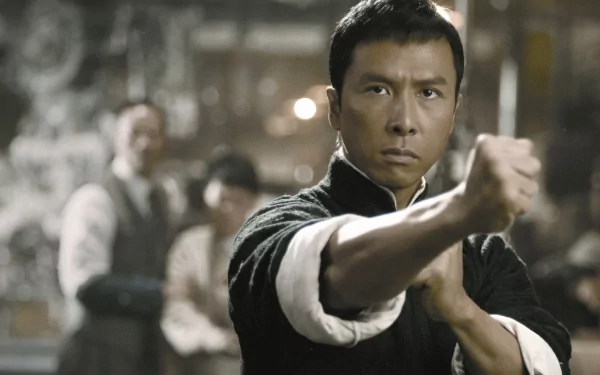A dramatic scene from the movie Ip Man, featuring the main character in a fighting stance, set against a blurred background. HD wallpaper captures the intensity of martial arts.