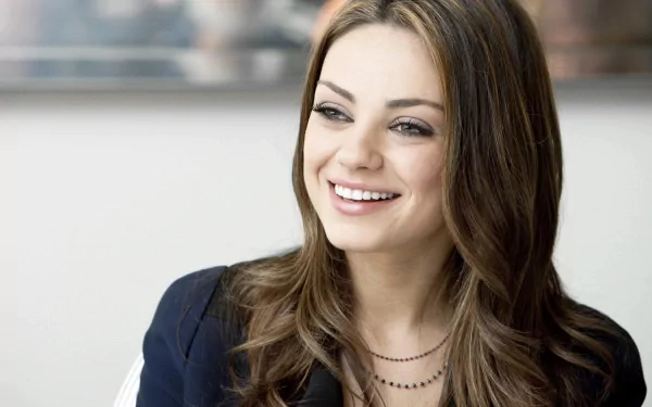 Mila Kunis smiles brightly in this 4K Ultra HD desktop wallpaper, showcasing her elegant style and charisma. A captivating background image for fans.