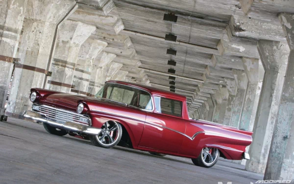 HD desktop wallpaper featuring a sleek red Ford Ranchero parked inside an industrial concrete structure with dramatic lighting and perspective.