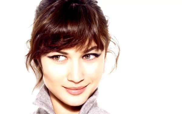 HD PC desktop wallpaper featuring a close-up portrait of celebrity Olga Kurylenko with soft lighting and a neutral background.
