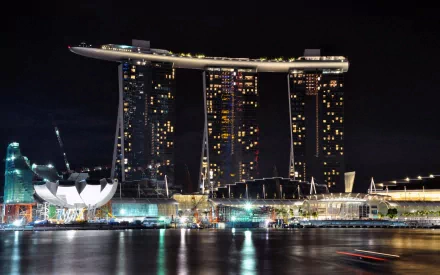 HD PC desktop wallpaper background: Singapore's man-made Marina Bay Sands lit at night, its three towers and rooftop SkyPark reflected on the calm bay.