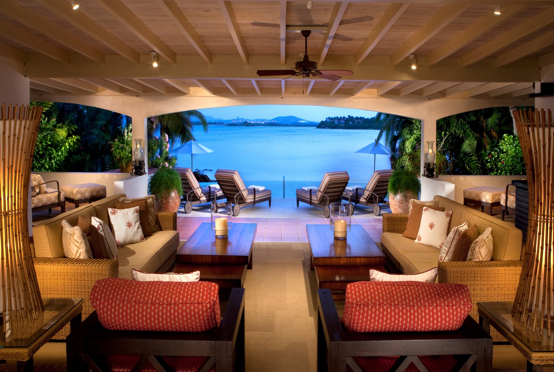 A luxurious man-made room with comfortable seating opens to a stunning ocean view, captured in a 4K Ultra HD PC desktop wallpaper and background.