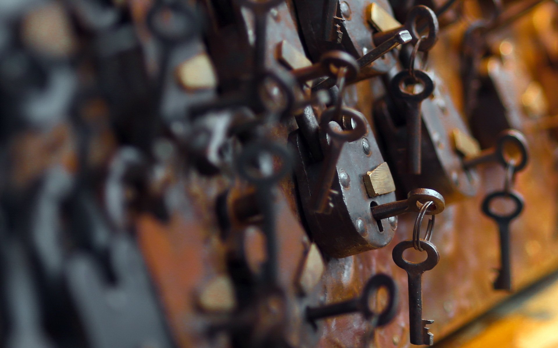 HD PC desktop wallpaper featuring a close-up of vintage man-made keys hanging on locks with a blurred background.