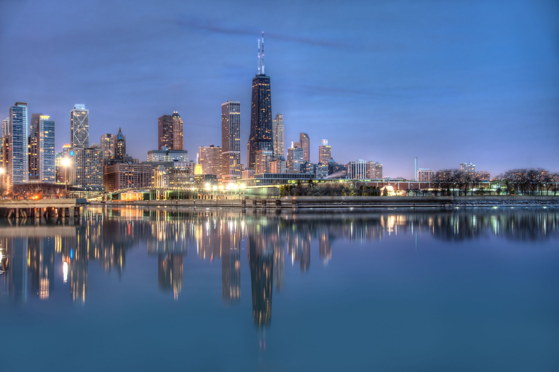 Nighttime cityscape of Chicago with illuminated skyscrapers reflecting on calm water, captured in stunning 4K Ultra HD resolution for a PC desktop background.