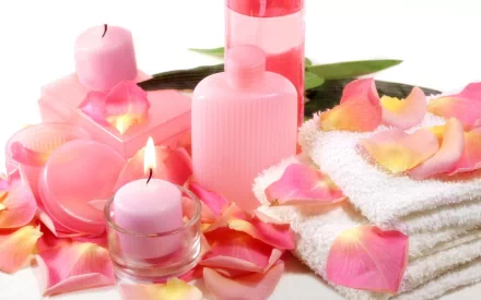 Pink candles, rose petals, a rolled towel, and spa bottles arranged in a serene still-life composition for an HD PC desktop wallpaper background.