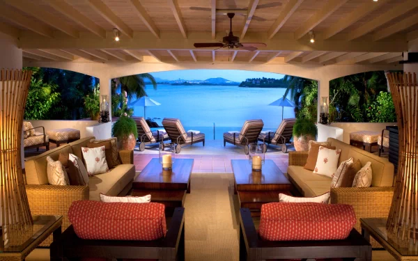 A luxurious man-made room with comfortable seating opens to a stunning ocean view, captured in a 4K Ultra HD PC desktop wallpaper and background.