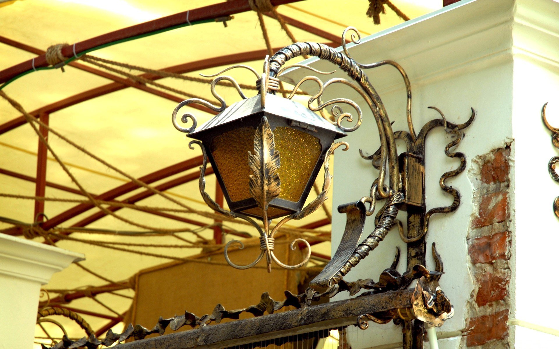 Close-up of a detailed man-made lamp post attached to a building, featured as an HD PC desktop wallpaper and background.