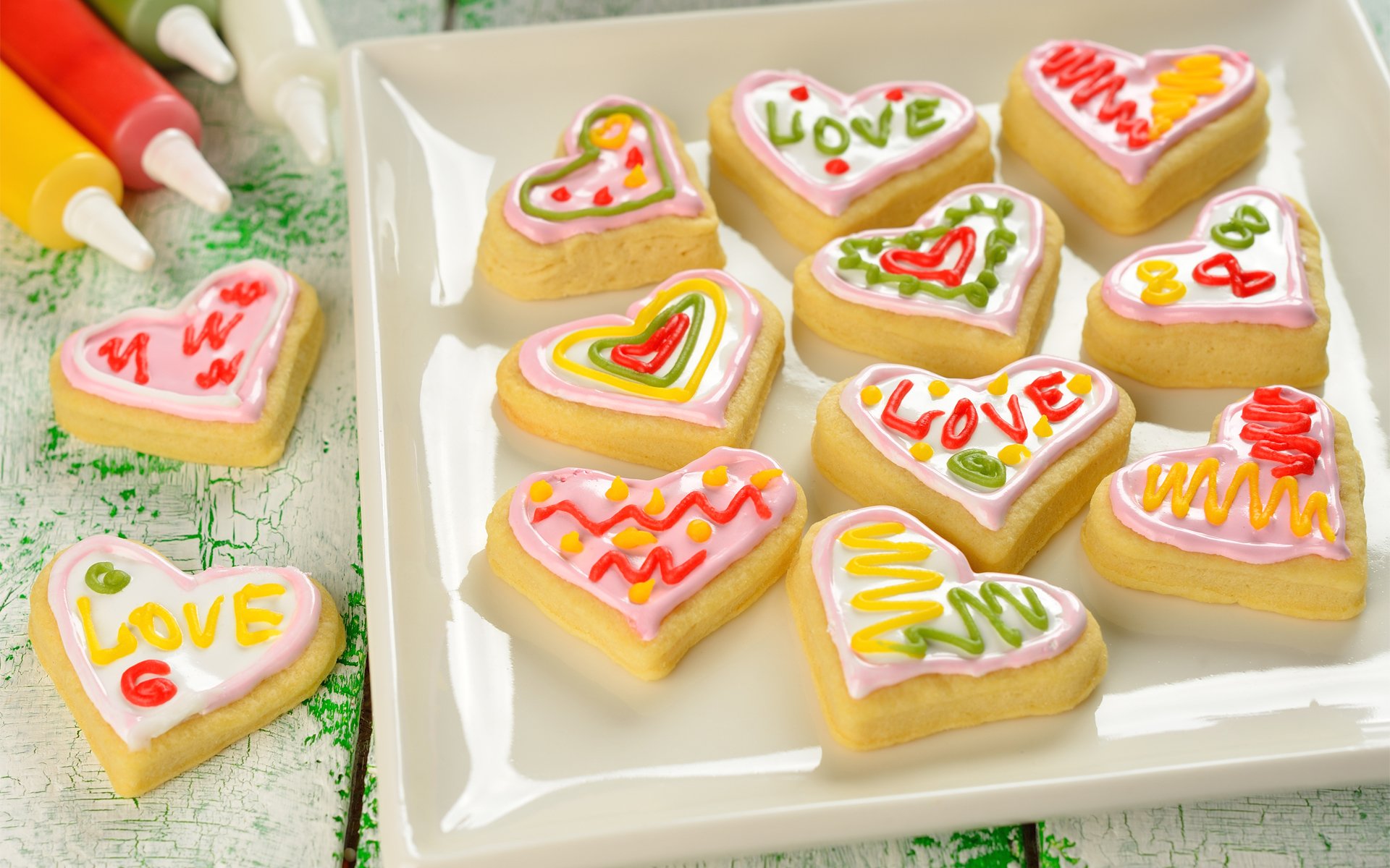 HD PC desktop wallpaper featuring heart-shaped cookies decorated with colorful icing and love-themed designs, capturing a warm and cheerful food moment.