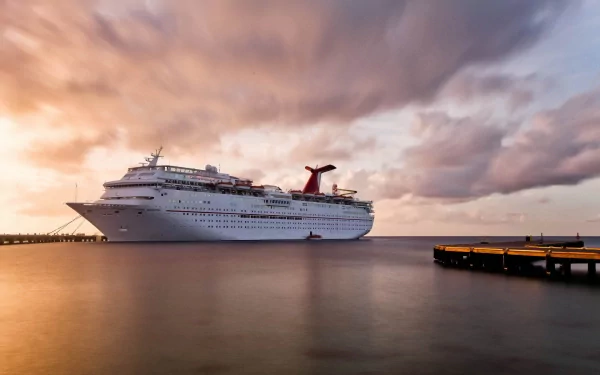 A stunning HD desktop wallpaper featuring a cruise ship docked near a pier, with tranquil waters and a colorful sunset sky in the background.