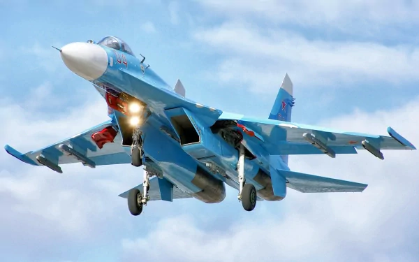 A Sukhoi Su-27 fighter jet takes off against a blue sky, showcasing its striking design and military prowess. This HD image serves as a dynamic desktop wallpaper.