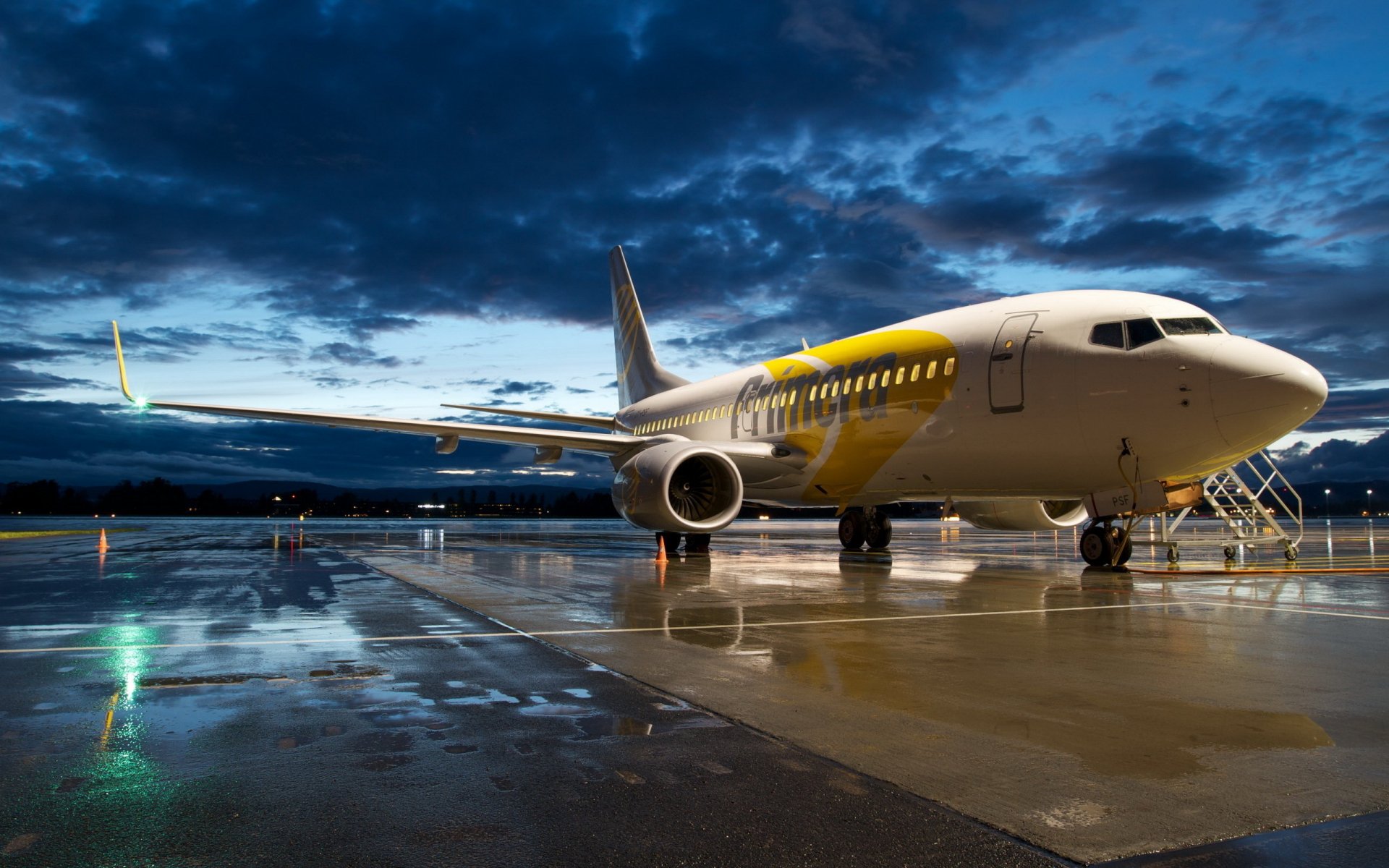 HD PC desktop wallpaper featuring a grounded aircraft on a wet runway under a dramatic, cloudy twilight sky.