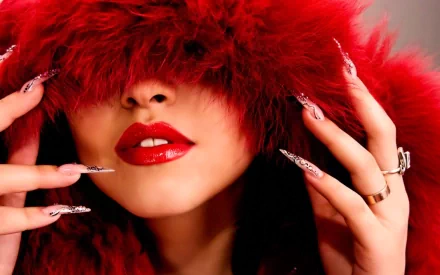 HD PC desktop wallpaper featuring a woman with glossy red lips partially hidden by a vibrant red fur hood, showcasing elegant nails and rings.